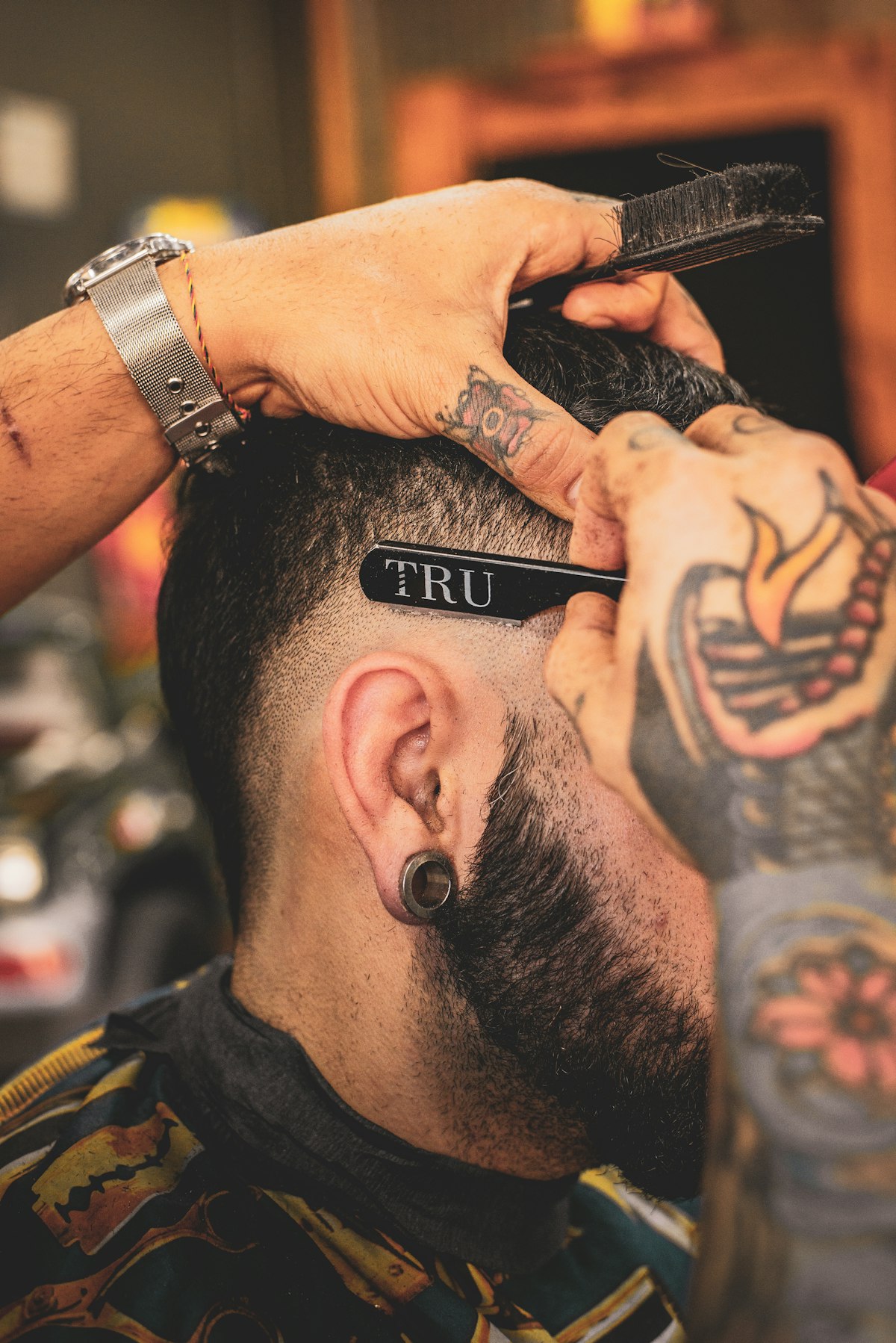 Illustrative barbering photograph of a man's hair being shaped with a razor; not Shane's staff, customers or work
